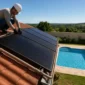 Técnico ajustando coletores de aquecimento solar de piscina em telhado com piscina residencial ao fundo