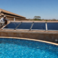 Piscina residencial com coletores solares térmicos instalados próximos ao telhado e técnico conferindo tubulação