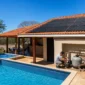 Piscina residencial com coletores de aquecimento solar no telhado e técnico verificando a casa de máquinas