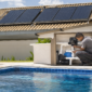 Piscina residencial com coletores solares térmicos no telhado e técnico verificando tubulação da casa de máquinas