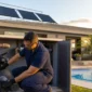 Técnico conferindo casa de máquinas de piscina com coletores de aquecimento solar no telhado e piscina ao fundo