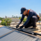 Técnico inspecionando coletor solar de piscina no telhado