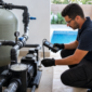 Técnico avaliando bomba e filtro em casa de máquinas de piscina