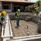 Obra de piscina residencial com ferragem, concreto e tubulações sendo conferidas por equipe técnica