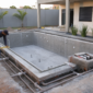 Construção de piscina residencial com estrutura de concreto tubulações e técnico conferindo nível no Faiçalville em Goiânia
