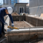 Técnico conferindo nível, ferragens e tubulação durante construção de piscina no Setor Central em Goiânia