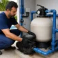 Técnico verificando bomba filtro registros e manômetro na casa de máquinas de piscina residencial