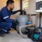 Técnico inspecionando filtro de areia, bomba e registros da casa de máquinas de piscina no Setor Pedro Ludovico em Goiânia