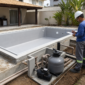 Piscina em obra com hidráulica vinil e técnico revisando instalação