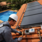 Técnico verificando placas de aquecimento solar para piscina em telhado no Setor Garavelo