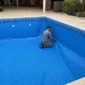 Técnico instalando revestimento vinílico azul em piscina vazia no Alphaville Flamboyant Residencial Araguaia em Goiânia
