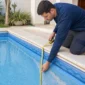Técnico medindo o revestimento de vinil azul de uma piscina antes da troca do bolsão