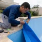 Técnico encaixando revestimento vinílico azul durante troca de vinil de piscina no Bairro Cardoso em Aparecida de Goiânia
