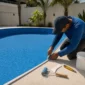 Técnico ajustando o revestimento vinílico azul durante troca de vinil de piscina no Jardim Goiás em Goiânia