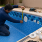 Técnico medindo vinil azul de piscina residencial para avaliar troca do revestimento e dispositivos hidráulicos