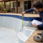 Técnico medindo borda e profundidade de piscina de vinil vazia para troca do revestimento no Nova Suiça em Goiânia