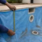 Técnico medindo vinil azul desgastado de piscina perto do skimmer e retorno antes da troca