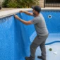 Técnico encaixando revestimento vinílico azul durante troca de vinil de piscina na Vila Brasília em Aparecida de Goiânia
