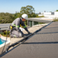 Técnico verificando coletores de aquecimento solar de piscina no telhado