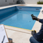 Técnico medindo comprimento, largura e profundidade de uma piscina para calcular o volume de água em Goiânia.