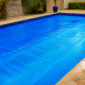 Capa térmica azul instalada sobre piscina residencial em Leopoldo de Bulhões