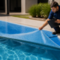 Capa térmica de piscina com desgaste e técnico analisando a manta