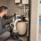 Técnico verificando manômetro válvulas bomba e filtro na casa de máquinas de uma piscina residencial