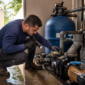 Técnico inspecionando vazamento na casa de máquinas da piscina