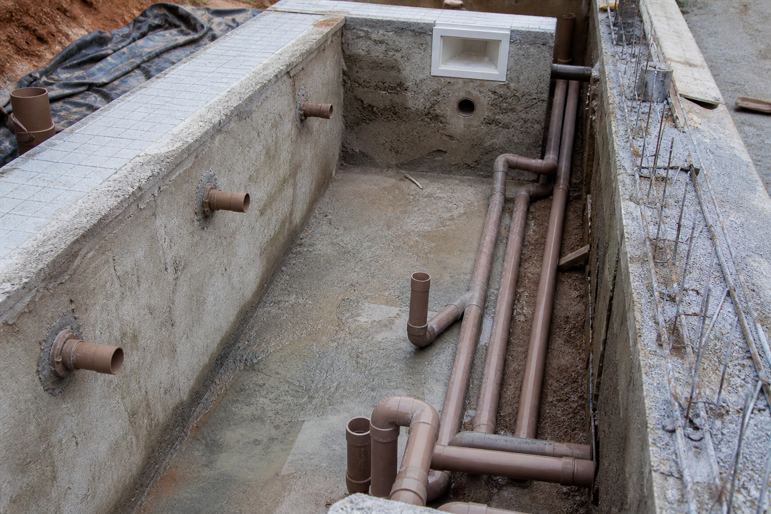 Tubulação hidráulica instalada em piscina de alvenaria antes do acabamento