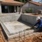 Piscina residencial em construção com estrutura de concreto e medição técnica na Vila São Tomaz, Aparecida de Goiânia