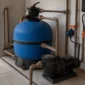 Técnico verificando filtro de areia, manômetro, bomba e tubulações da casa de máquinas de piscina no Chácara São Pedro