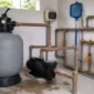 Filtro de areia, bomba, registros e manômetro em casa de máquinas de piscina residencial