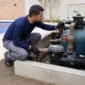Técnico verificando manômetro filtro de areia bomba e tubulações de piscina residencial