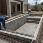 Piscina residencial em construção com estrutura de concreto e medição técnica no Setor dos Funcionários, Goiânia