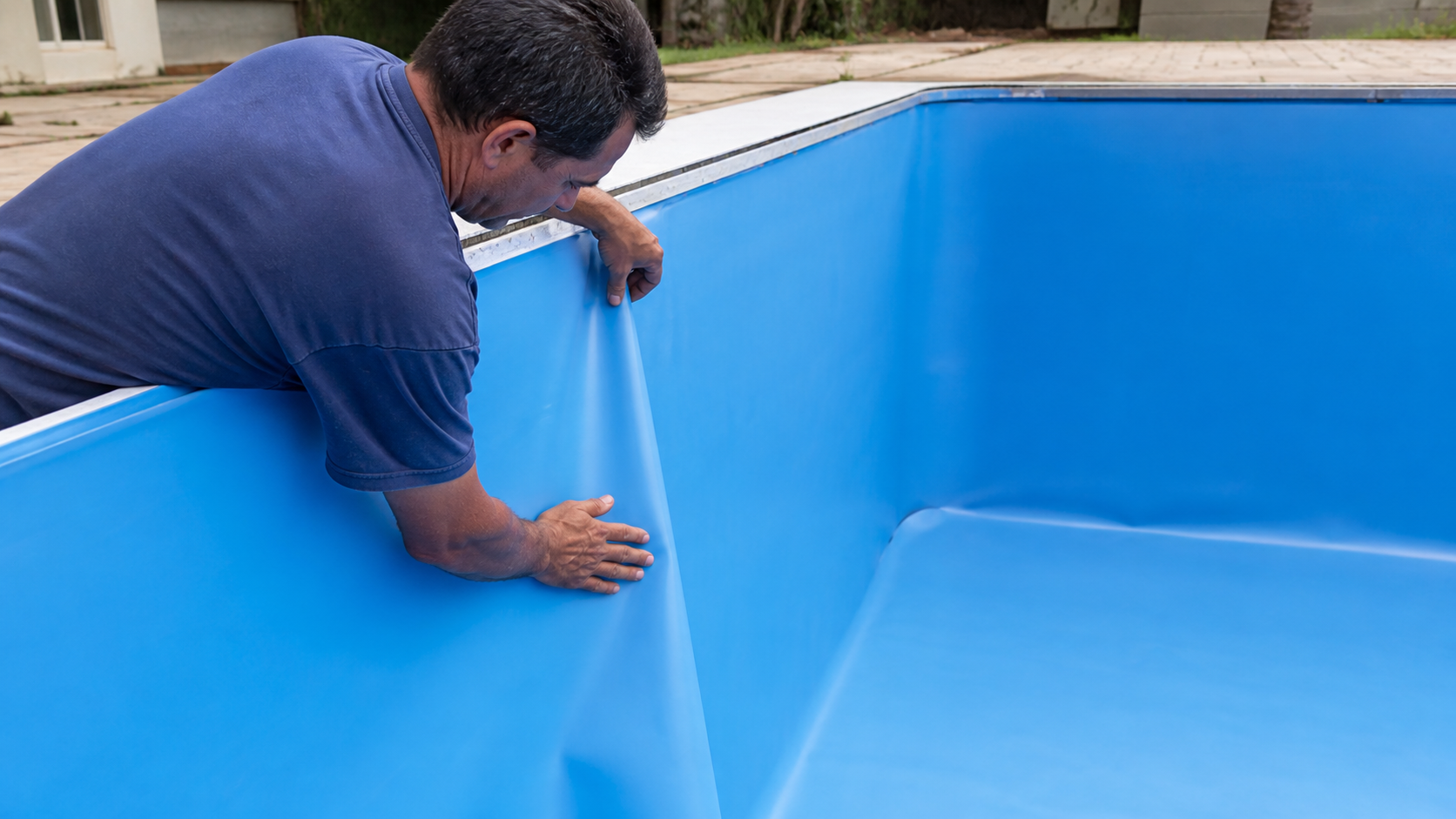 Instalador ajustando novo revestimento de vinil azul nas paredes de uma piscina
