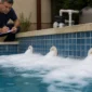 Espuma branca concentrada ao redor dos bocais de retorno de uma piscina enquanto técnico observa