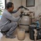 Técnico verificando filtro de piscina após entrada de poeira de obra