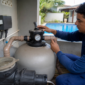 Técnico verificando manômetro e válvula seletora do filtro de piscina
