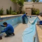 Técnicos medindo piscina de vinil vazia com revestimento antigo parcialmente removido no Pontal Sul