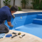 Profissional inspecionando vinil de piscina enrugado perto dos degraus