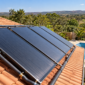 Coletores de aquecimento solar instalados em telhado com piscina residencial ao fundo em Palminópolis
