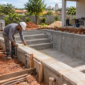 Obra de piscina residencial em construção com profissional conferindo o projeto hidráulico em Goiânia