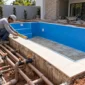 Piscina residencial em construção no Parque Oeste Industrial, Goiânia, com revestimento de vinil, tubulações e conferência de medidas