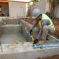 Obra de piscina residencial em construção com profissional conferindo o projeto hidráulico em Goiânia