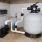 Filtro de areia, bomba, manômetro, válvulas e tubulação de PVC em casa de máquinas de piscina