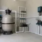 Filtro de areia, bomba, registros e manômetro em casa de máquinas de piscina residencial