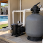 Filtro de areia, motobomba, manômetro e tubulações em casa de máquinas de piscina