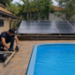 Casa de máquinas com bomba, filtro, tubulações e coletores de aquecimento solar para piscina