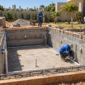 Obra residencial de construção de piscina com estrutura, ferragens e tubulações hidráulicas