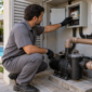Técnico verificando o quadro elétrico protegido e a motobomba em uma casa de máquinas de piscina em Goiânia.